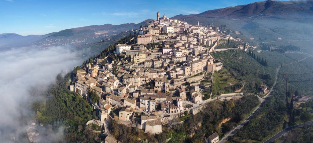 Aerial view of majestic ancient city of San Marino located on green verdant hill on spacious hilly terrain on clear sunny day