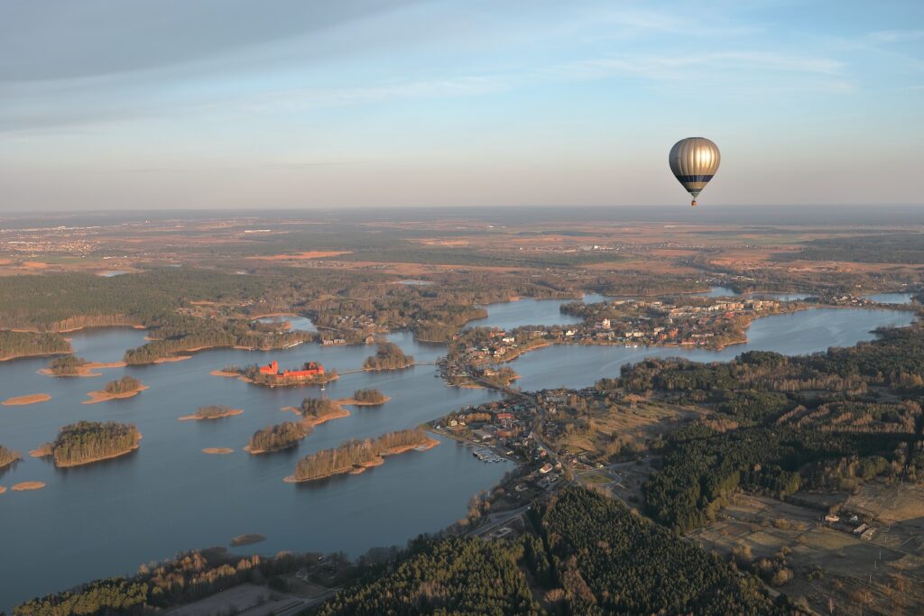 a hot air balloon flying over a large body of water